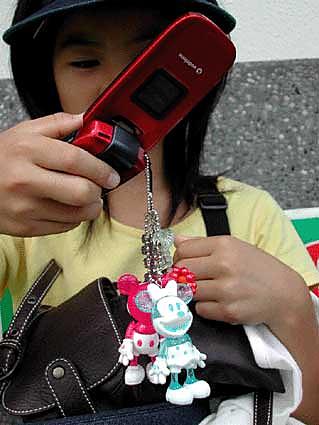 Japanese girl showing her mobile phone with pendants