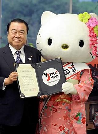The horror: a human-scale Kitty standing next to a Japanese minister